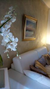a living room with a couch and a vase with white flowers at Atelier in Portogruaro