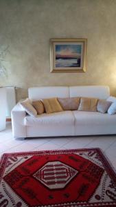 Sofá blanco en la sala de estar con alfombra roja en Atelier, en Portogruaro