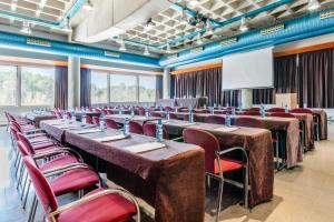 une salle de conférence avec des tables et des chaises et un tableau blanc dans l'établissement Exe Campus, à Bellaterra