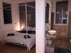 Schlafzimmer mit einem Bett mit Baldachin aus Metall und einem Badezimmer in der Unterkunft Via Dei Dori B&B in Mirano