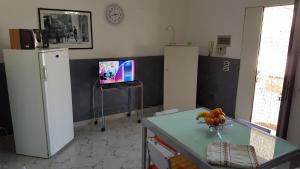 kuchnia z 2 lodówkami i stołem z telewizorem w obiekcie Villa Gallina w mieście Avola