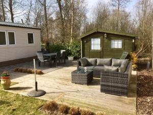 eine Terrasse im Hinterhof mit einem Sofa und einem Haus in der Unterkunft Chalet Casa Cowabunga in Earnewâld