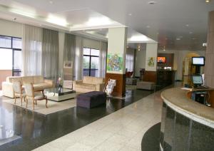 a lobby with a living room with furniture and a tv at Blue Tree Towers Curitiba Batel in Curitiba