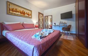 a bedroom with a bed with a pink comforter at B&BLaTosca in Marina di Massa