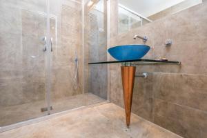 a bathroom with a glass shower with a blue sink at B&B Le Dune - Self Check in in Lascari