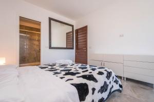 a bedroom with a black and white cow blanket on a bed at B&B Le Dune - Self Check in in Lascari