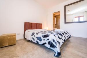 a bedroom with a black and white bed and a mirror at B&B Le Dune - Self Check in in Lascari