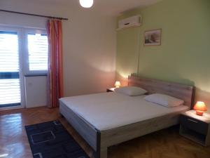 a bedroom with a bed with two pillows and two lamps at Apartments Smiljana in Omiš