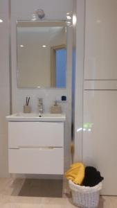 a white bathroom with a sink and a mirror at Apartament nr 19 in Dziwnówek