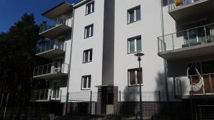 a white building with balconies on the side of it at Apartament nr 19 in Dziwnówek