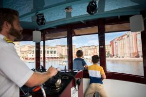 two people are on a boat in the water at Universal's Loews Portofino Bay Hotel in Orlando