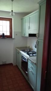 a kitchen with blue cabinets and a stove top oven at Hygge Chalet a Champoluc in Champoluc