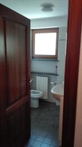 a bathroom with a toilet and a sink and a window at Hygge Chalet a Champoluc in Champoluc