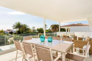 un comedor blanco con una mesa y sillas blancas en VILLA LUCIA B17 en Santo Tomás