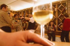 eine Person, die ein Glas Wein in einer Bar hält in der Unterkunft Gasthof Hotel Zum Weinberg in Kohfidisch