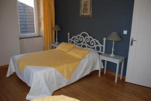 a bedroom with a bed and a table and a window at Maison d' hôtes individuelle La Relinquière in Milhac