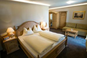 a bedroom with a large bed and a couch at Furggerhof in Tirolo