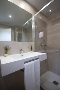 a bathroom with a white sink and a shower at Hotel Río Asón in Ramales de la Victoria