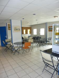 a waiting room with tables and chairs at Lac'Hotel France in Montréal La Cluse