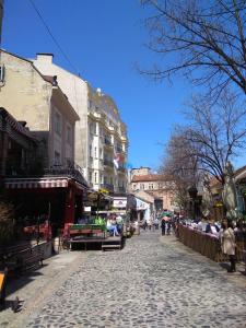 a cobblestone street in a city with people walking at Bohemian Dawn Apartment in Belgrade