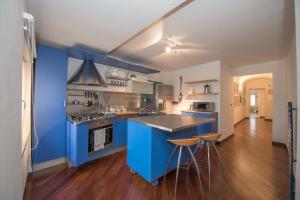 a large kitchen with blue cabinets and wooden floors at Le Dimore di Casa Mattei n°9 in Prato