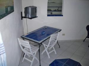 un tavolo con due sedie e una televisione sopra di L'Isolana Case Vacanza Palma 2 a Ponza