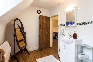 La salle de bains est pourvue d'un lavabo et d'un miroir. dans l'établissement Inglewood House, à Monmouth