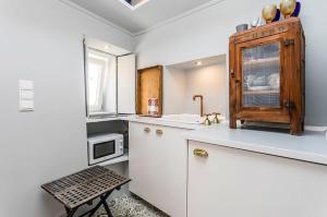 a kitchen with white cabinets and a microwave at Unique Studio House | City Centre in Lisbon