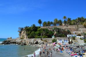 a group of people on a beach near the ocean at Rico Apartaments Parador in Nerja