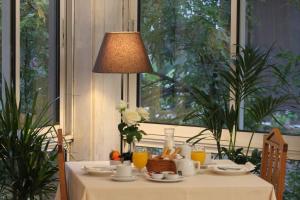 un tavolo con una tovaglia bianca e una lampada di Achillion Hotel ad Atene