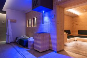una sauna con illuminazione blu in una stanza di Hotel El Paster a Pozza di Fassa