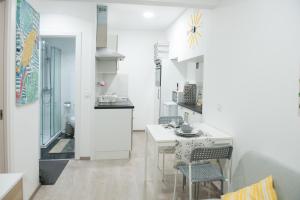 Una cocina y un comedor con mesa y sillas. en Tropical house, en Sesimbra