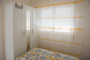 Un dormitorio con una cama y una ventana con cortinas. en Tropical house, en Sesimbra