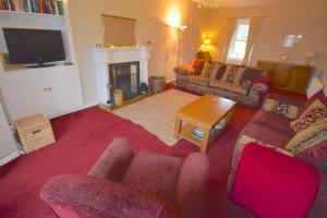 a living room with a couch and a fireplace at Lettermay House in Lochgoilhead