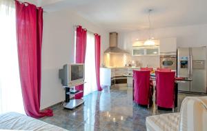 a living room with red curtains and a kitchen at Apartments Duje in Dugi Rat