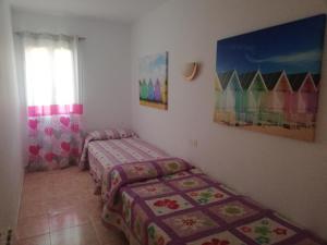 a bedroom with two twin beds and a window at Galdana Sun And Beach in Cala Galdana