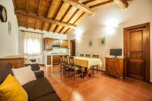 a living room with a table and a kitchen at Il Poggio degli Olivi in Bettona