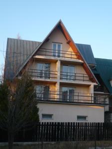 a large house with a gambrel roof at Pokoje gościnne w górach in Kościelisko +56 photos
