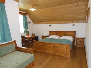 a bedroom with a wooden bed and a chair at Šport center Prodnik in Ljubno