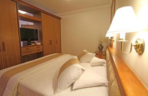 a hotel room with a bed and a lamp at Blue Tree Towers Curitiba Batel in Curitiba