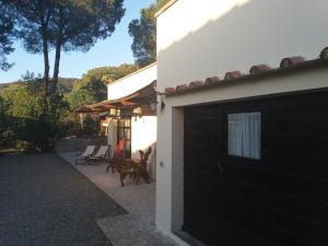 uma casa branca com uma garagem preta e um pátio em Villa Timothy em Procchio