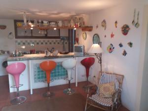 a kitchen with red and white stools in front of a counter at Villa Timothy in Procchio
