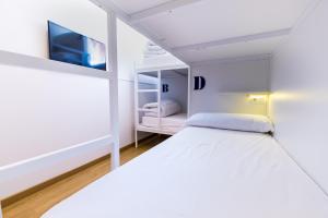 1 dormitorio blanco con 1 cama y TV en Far Home Bernabeu, en Madrid