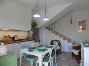 kuchnia i jadalnia z białym stołem i krzesłami w obiekcie Casa Giglio w mieście Carloforte