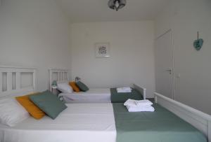 Villaggio AzzurroにあるColori a mareの白いベッドルーム1室(ベッド2台、タオル付)