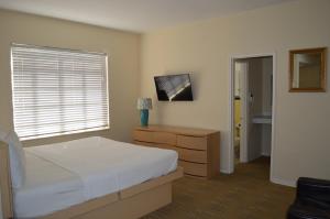 1 dormitorio con 1 cama, vestidor y ventana en Island House South Beach, en Miami Beach