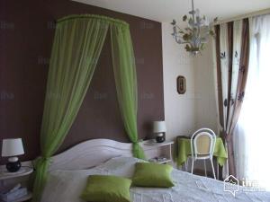 - une chambre avec un lit et des rideaux verts dans l'établissement "les amandiers", à Mittelwihr