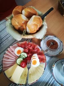 une table avec une assiette d'aliments avec des œufs et du pain dans l'établissement Frühstückspension Sterr, à Strebersdorf