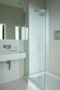 a bathroom with a glass shower and a sink at Hastings House in Hastings