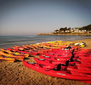 a group of kayaks lined up on the beach at Cala Azul 304-306 Tamarit in Tamarit